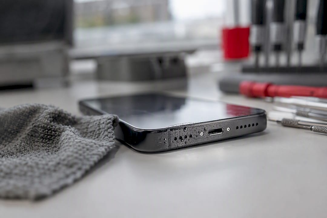 Smartphone charging port with moisture droplets close-up