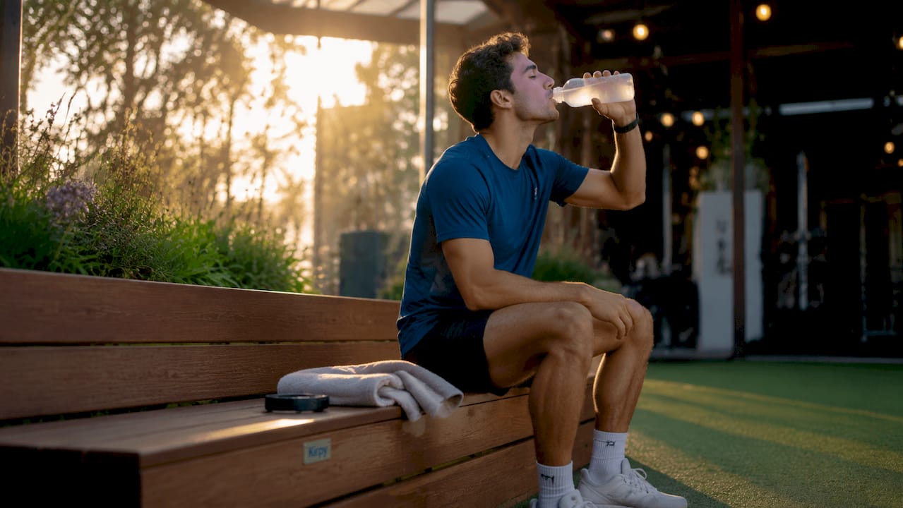 Een sporter lest zijn dorst met een dorstlesser boordevol elektrolyten.