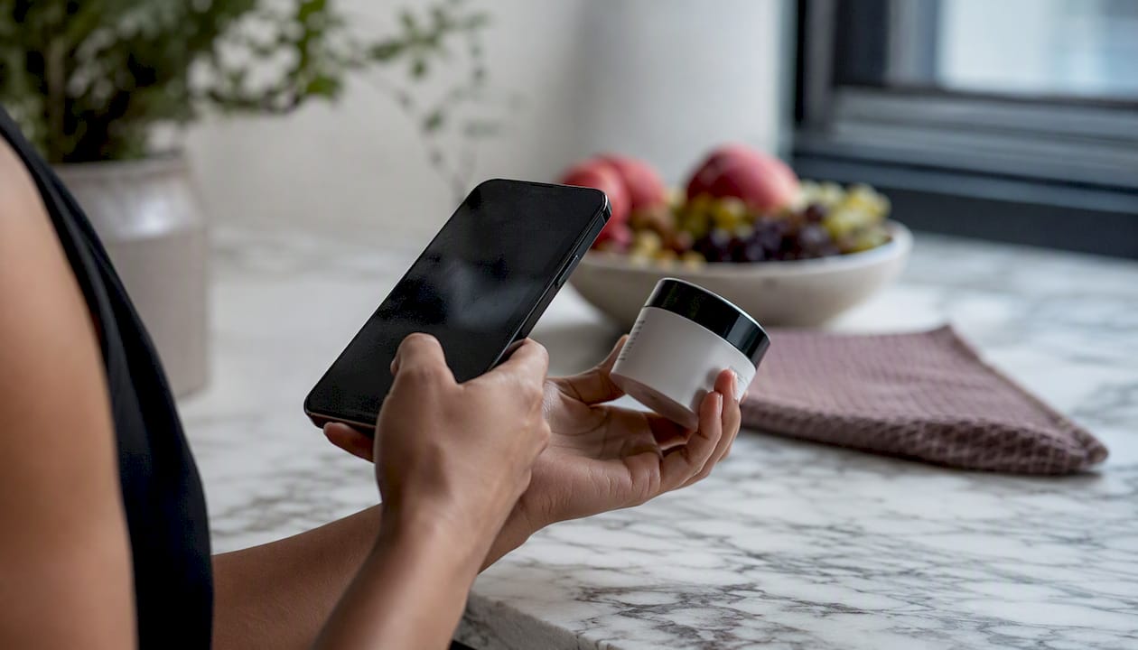 Hand scanning skincare label with phone