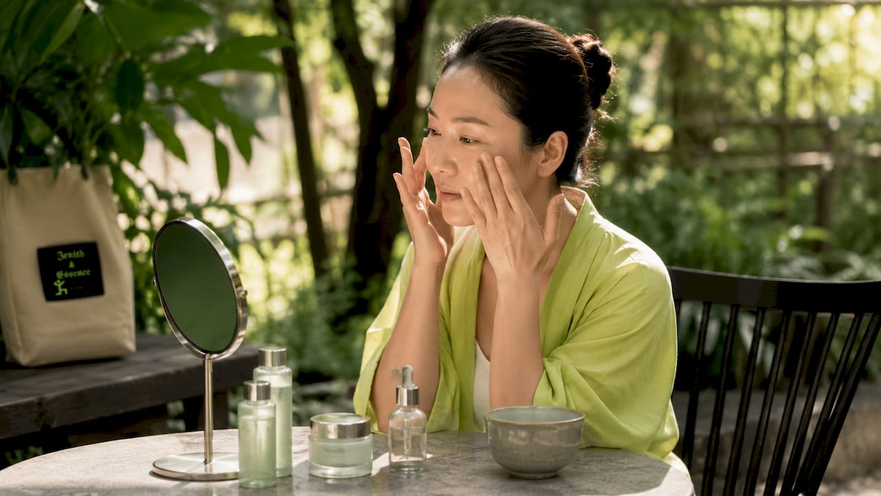 Woman applying concentrated serum at home vanity