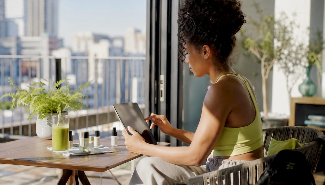 Woman browsing beauty products at kitchen table