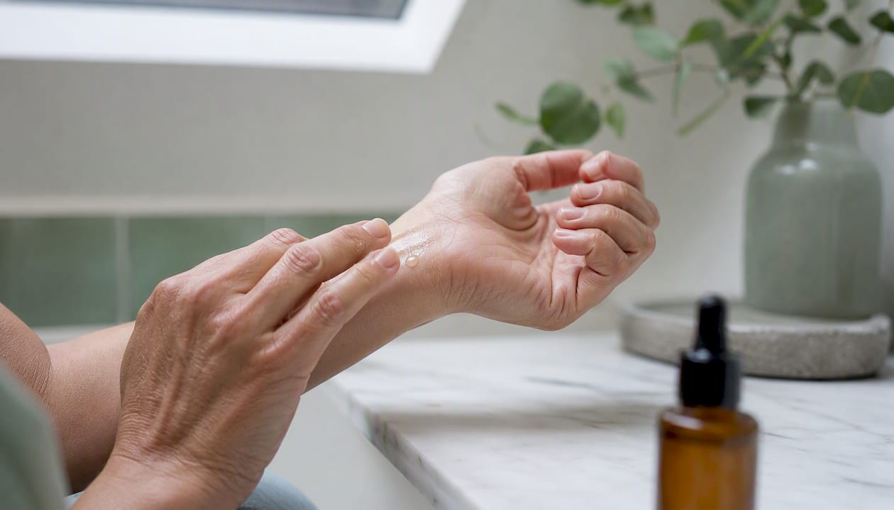 Applying oil-based vitamin C serum on mature skin