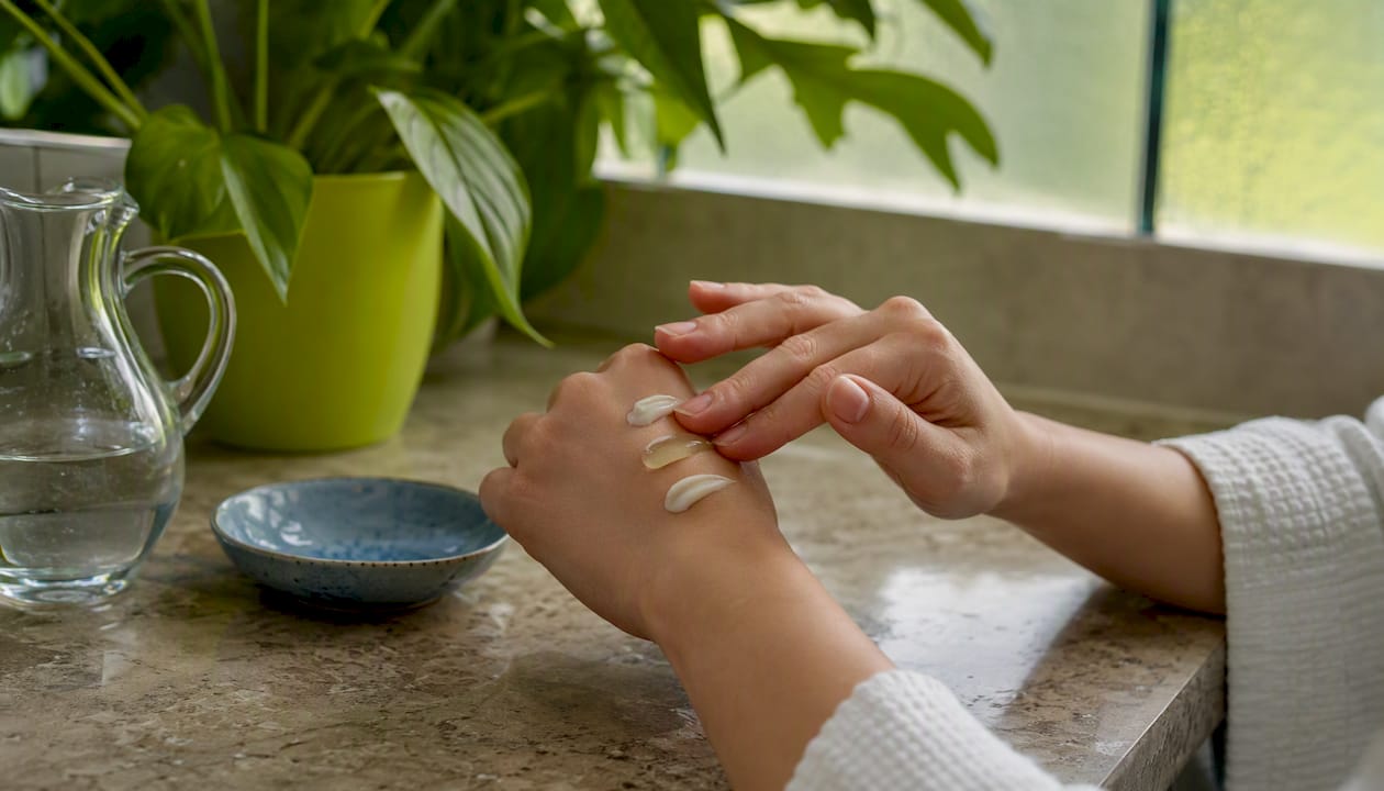 Hands layering moisturizer and azelaic acid gel
