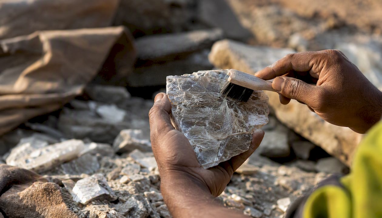 Hands cleaning mica mineral dust in mining setting