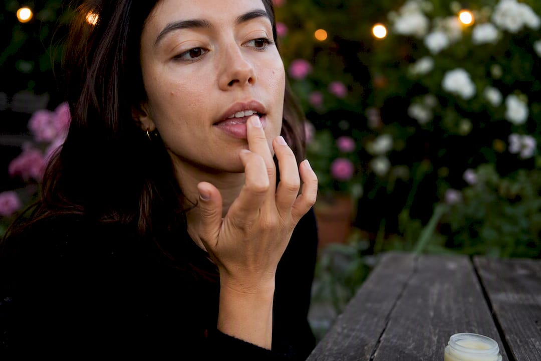 Applying multi-use balm to lips
