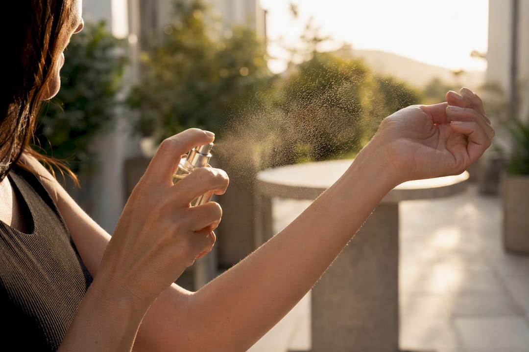 Person spraying perfume on wrist
