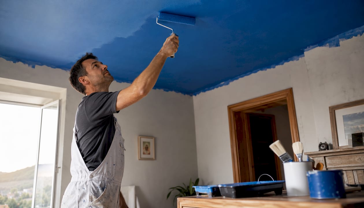 Professional painter applying ceiling paint
