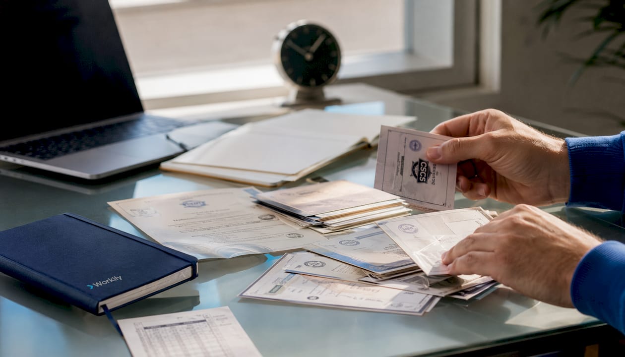Hands holding tradesperson insurance and certification documents