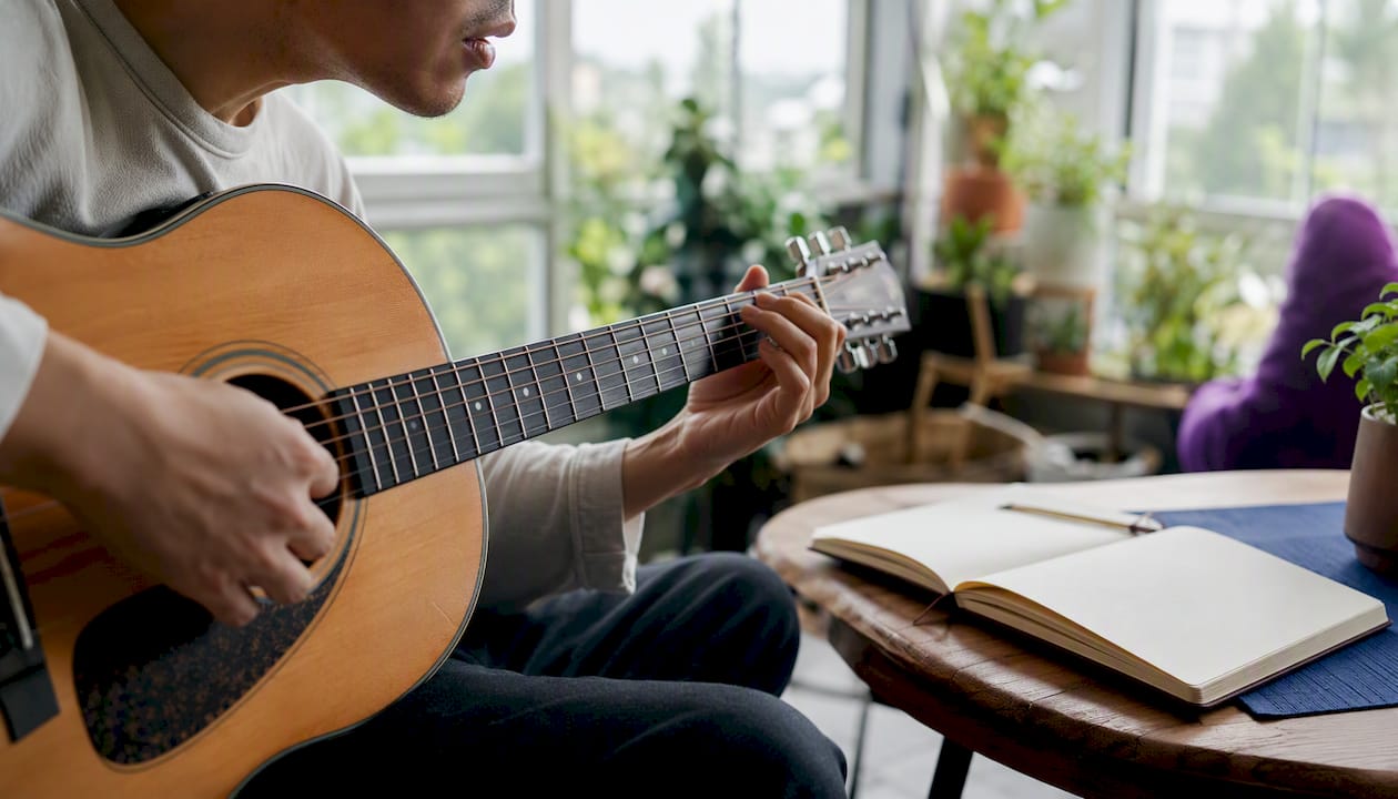 Hands strumming guitar humming melody