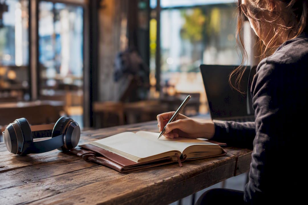 Journal and headphones on wooden table