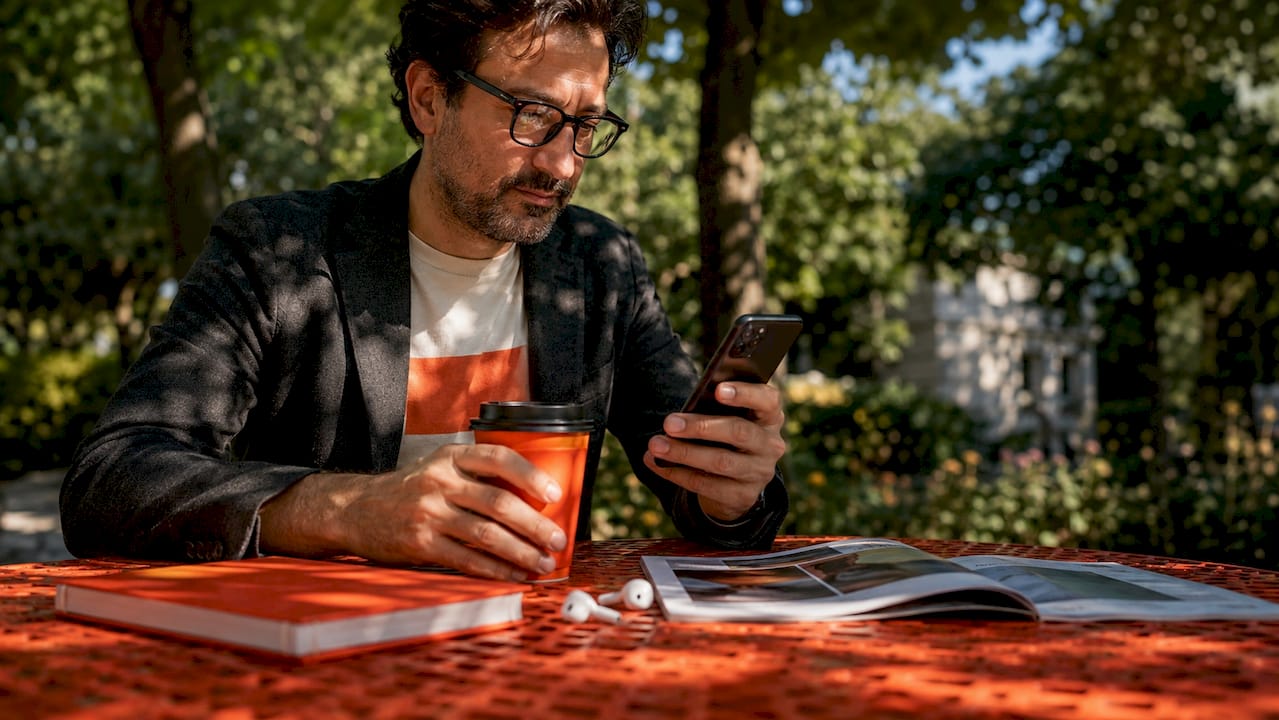 Man reviewing website content on smartphone in café