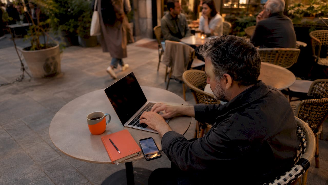 User typing on laptop with support materials nearby