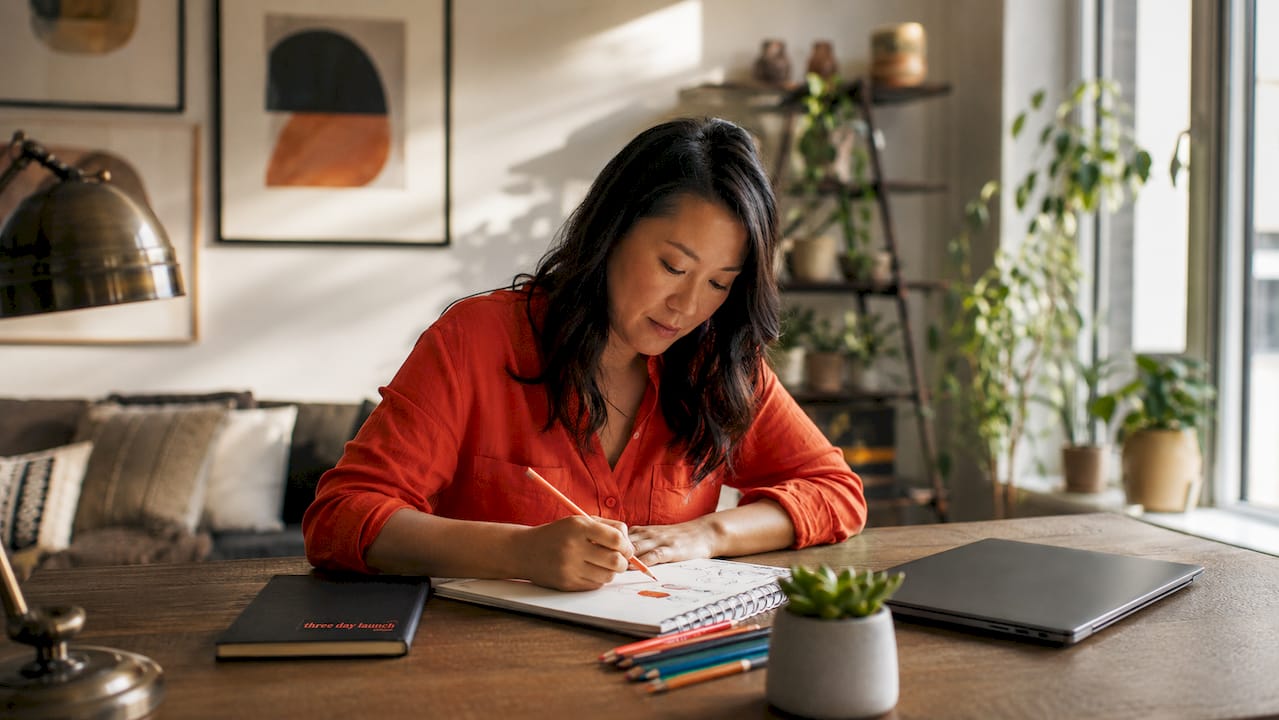 Solopreneur sketching branding ideas at home desk