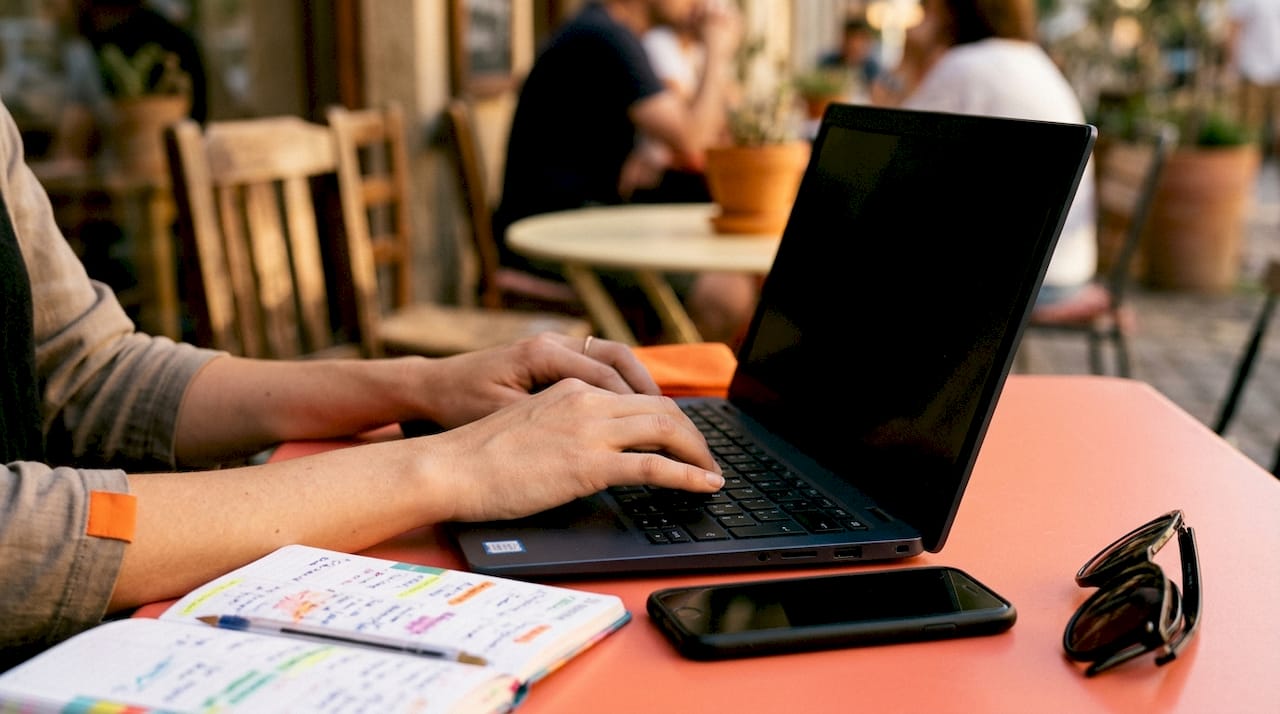 Hands typing on laptop focusing on UX design