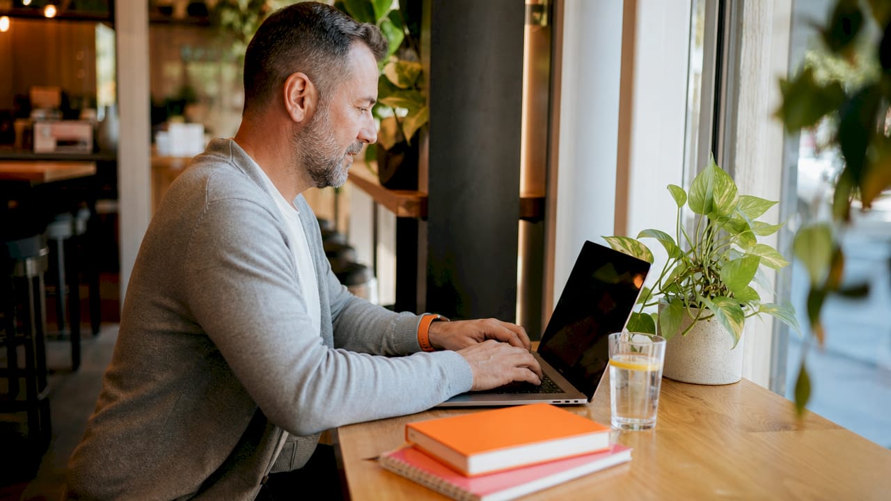 Hands typing About page content on laptop