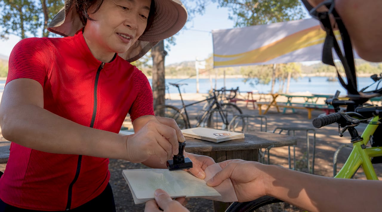 Cyclist receiving a stamp at Korean checkpoint booth