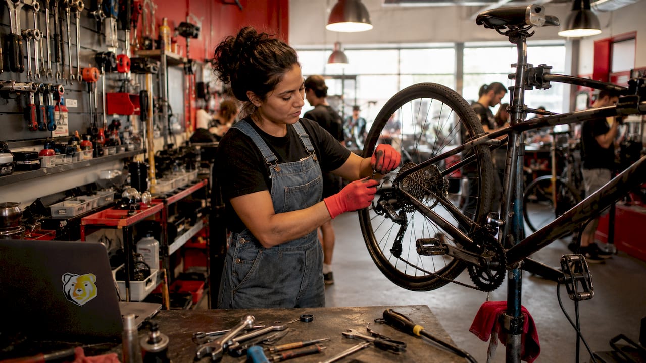 Side view of mechanic demonstrating bike repair indoors