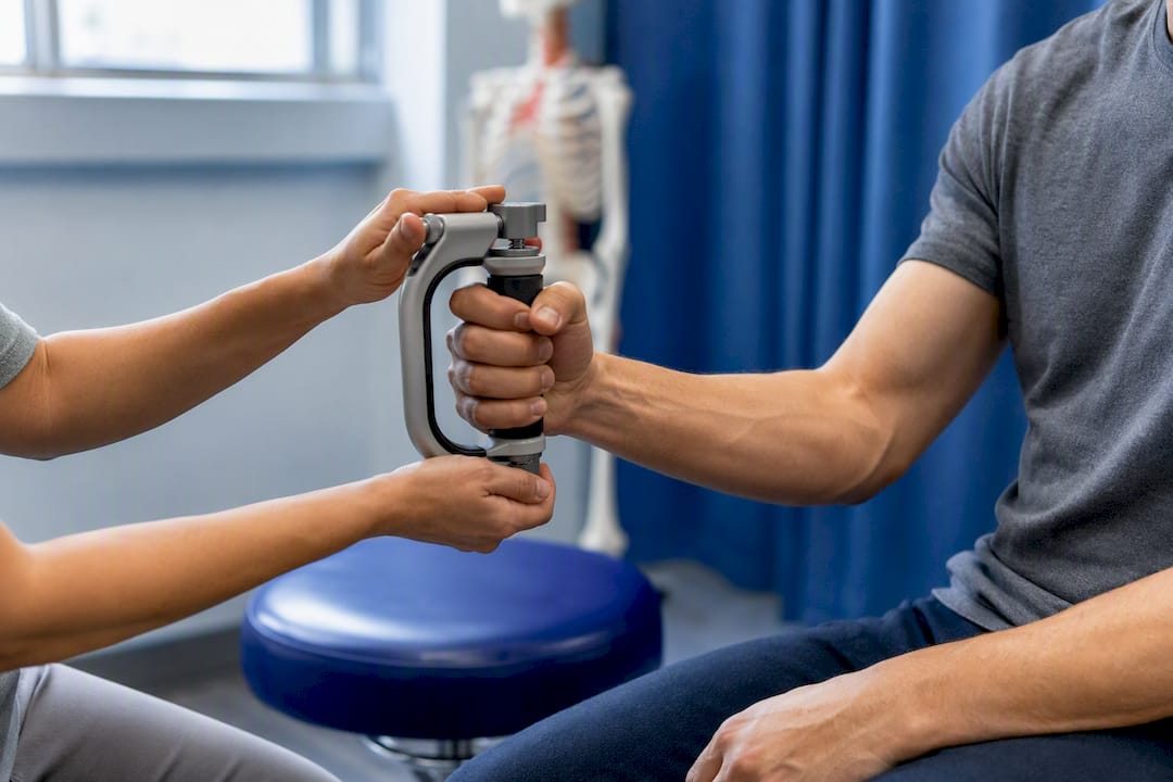 Clinician measuring patient grip strength