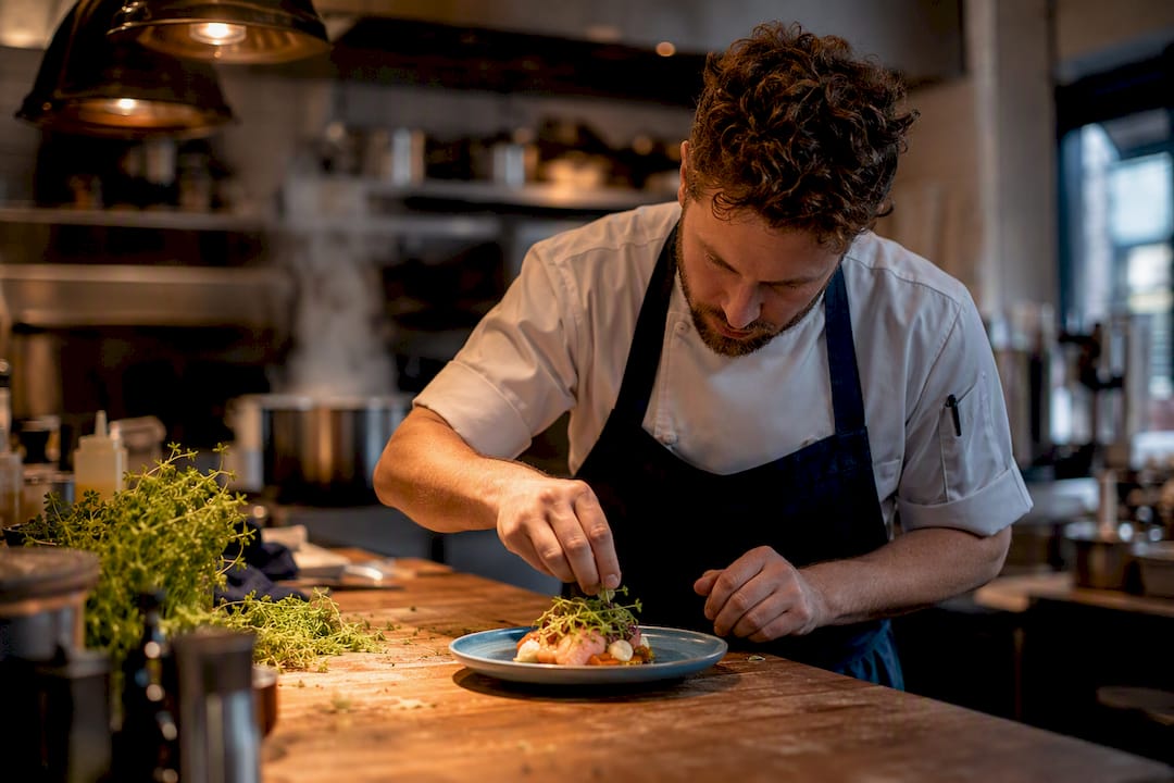 Chef plating appetizer in event kitchen