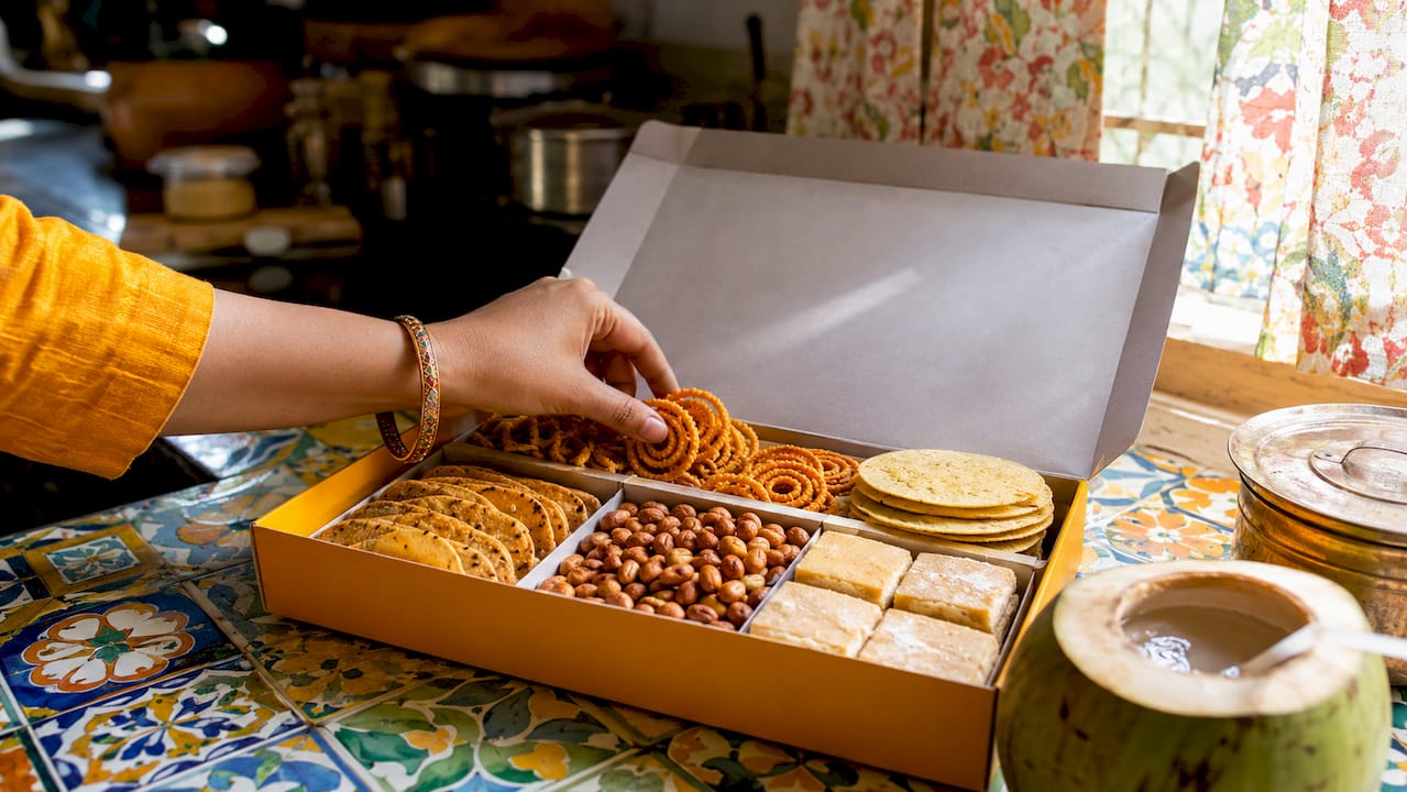 Open curated Indian snack box with assorted traditional snacks