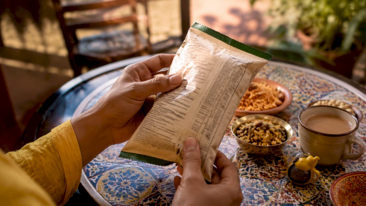 Hands examining Indian snack ingredient label