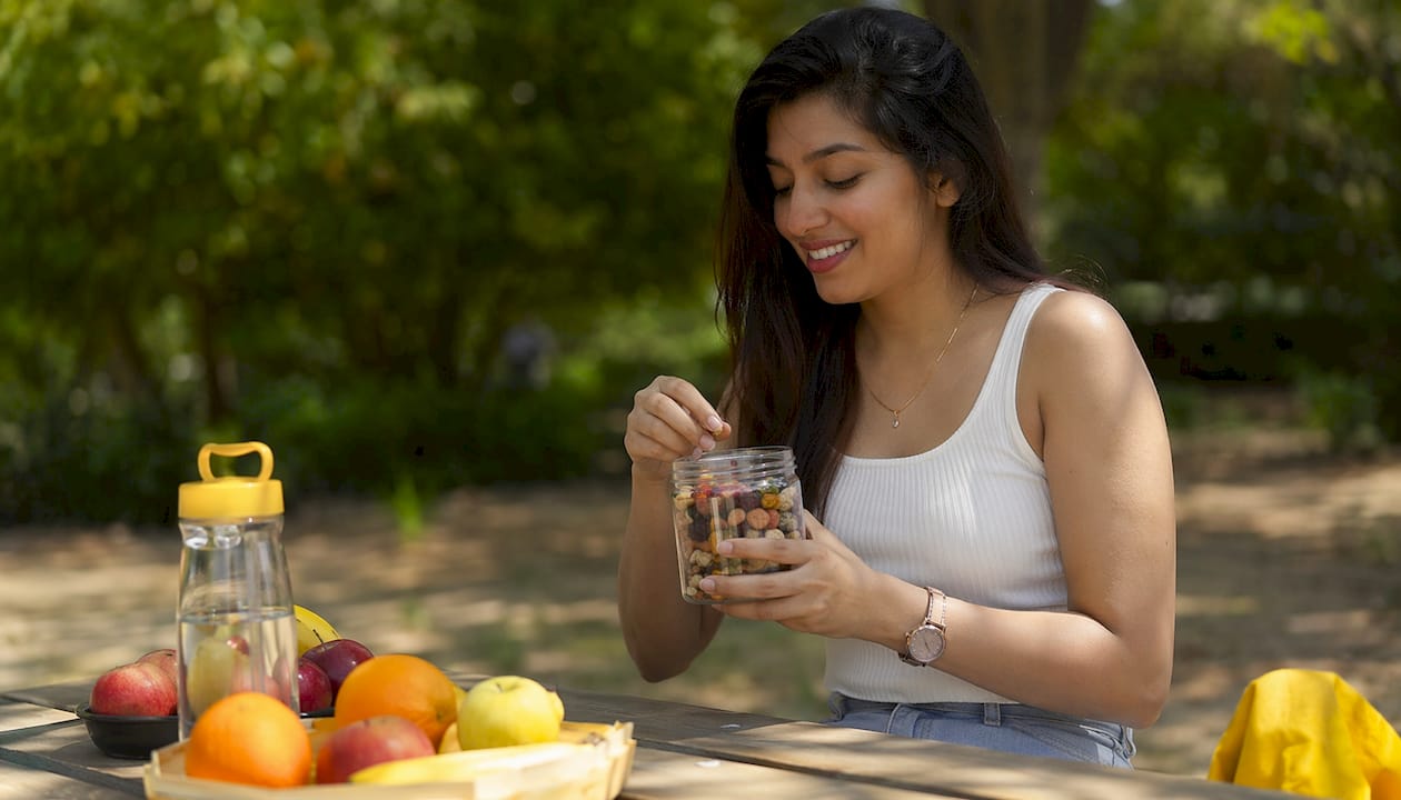 Woman holding container of mixed grab and go snacks