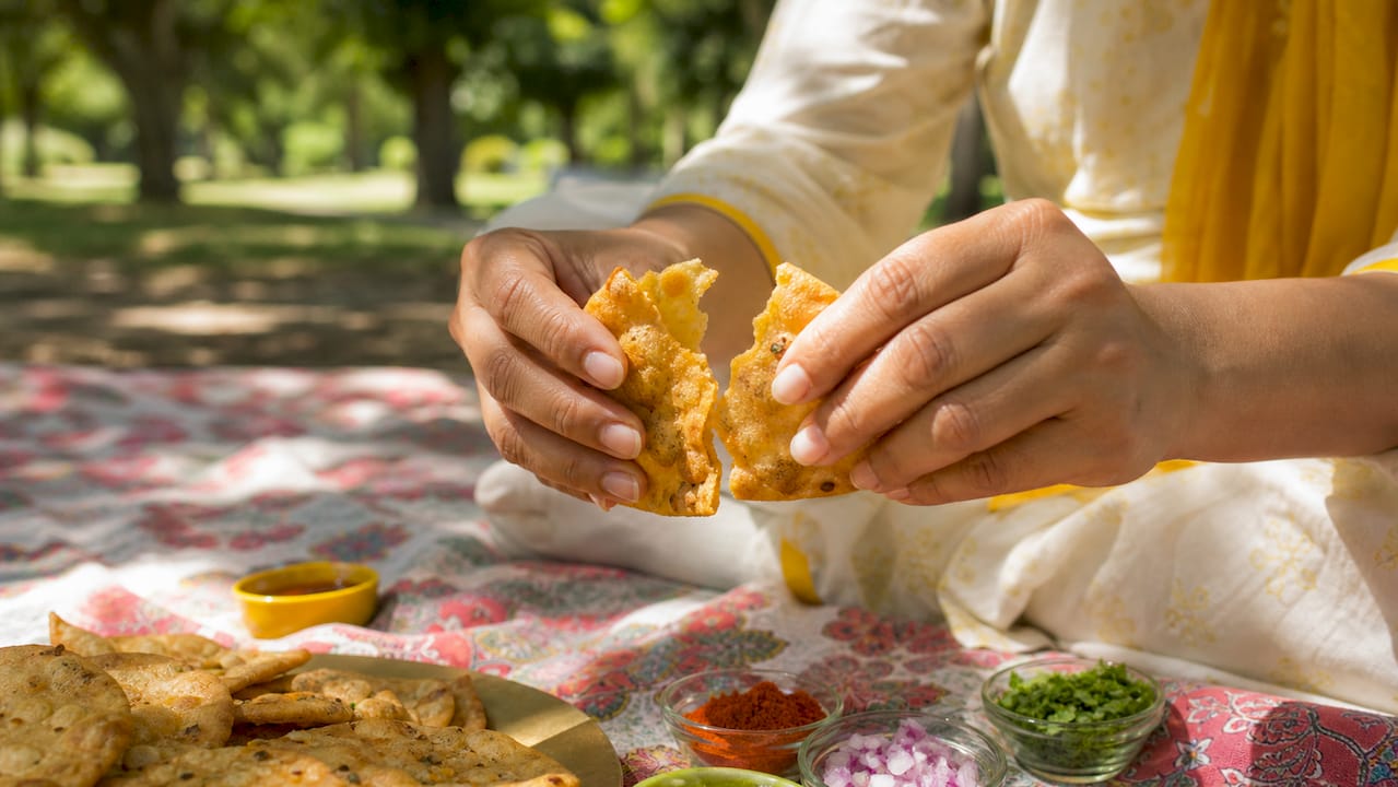 Hands breaking crispy traditional snack at wooden table