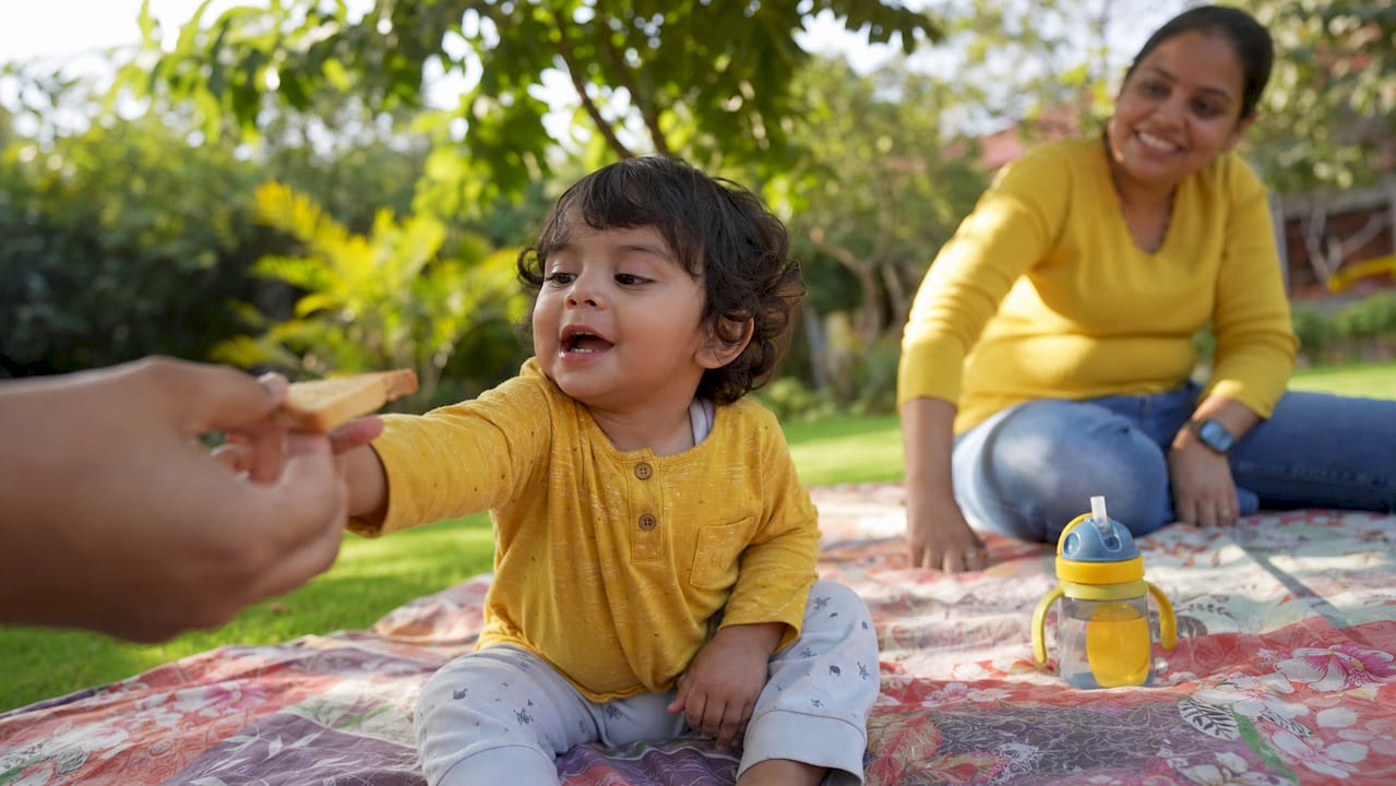 Toddler reaching for suji rusk biscuit