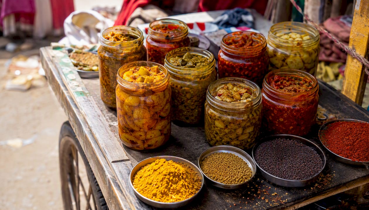 Jars of Indian pickles with spices on a shelf