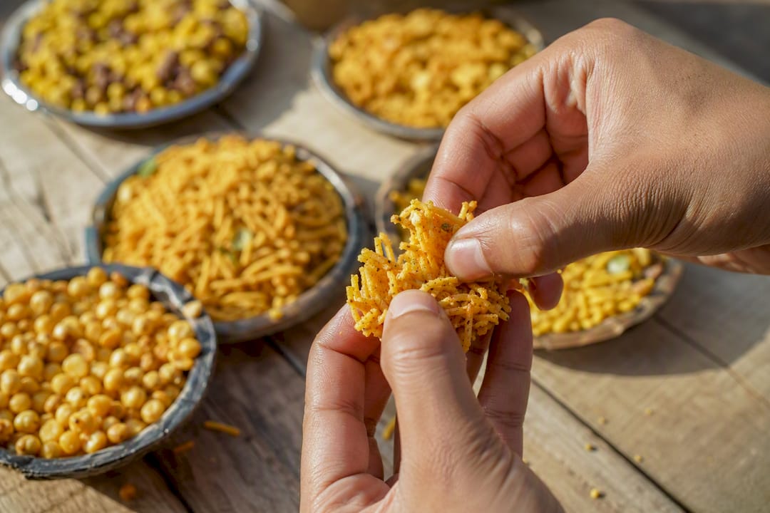 Hand breaking mathri biscuit among variety of namkeen
