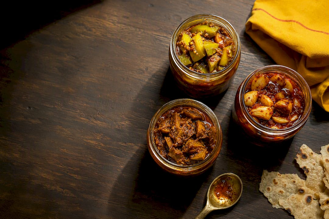 Three Indian pickle jars with roti