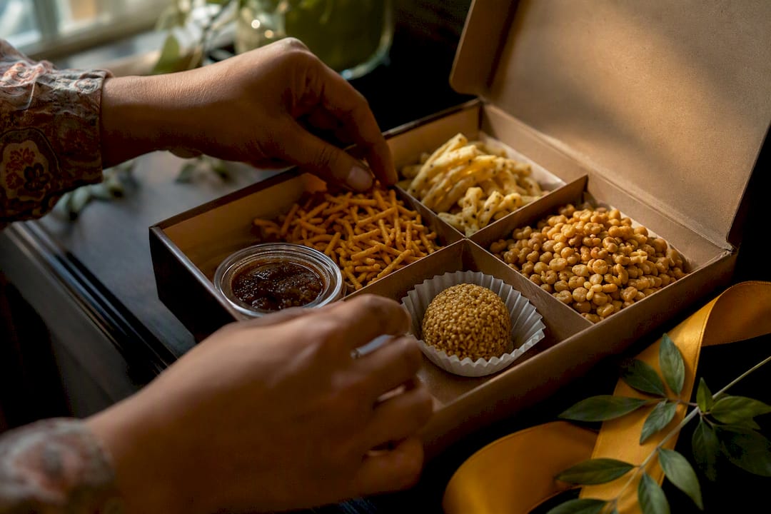 Hands arranging snacks inside gift box