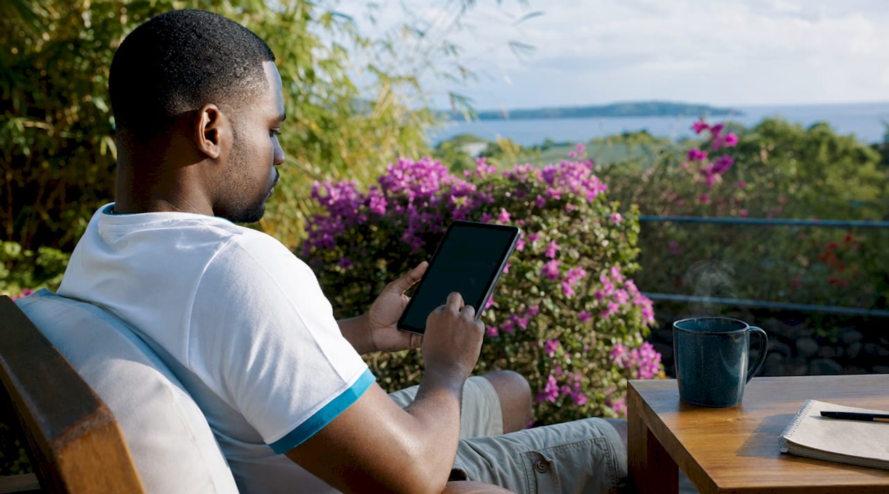 Man completing survey on tablet at home desk