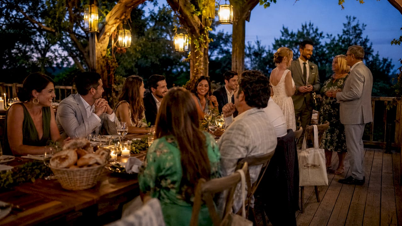 Guests at outdoor rehearsal dinner under string lights