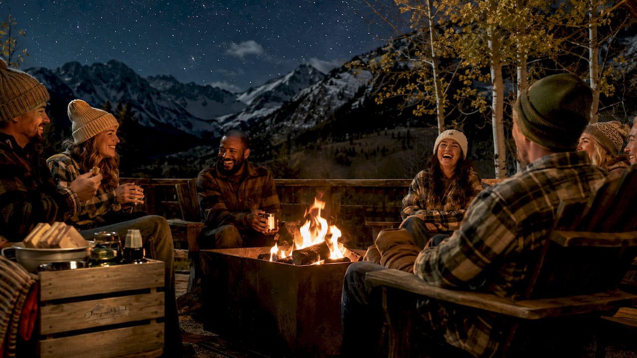 Guests around bonfire at mountain welcome party