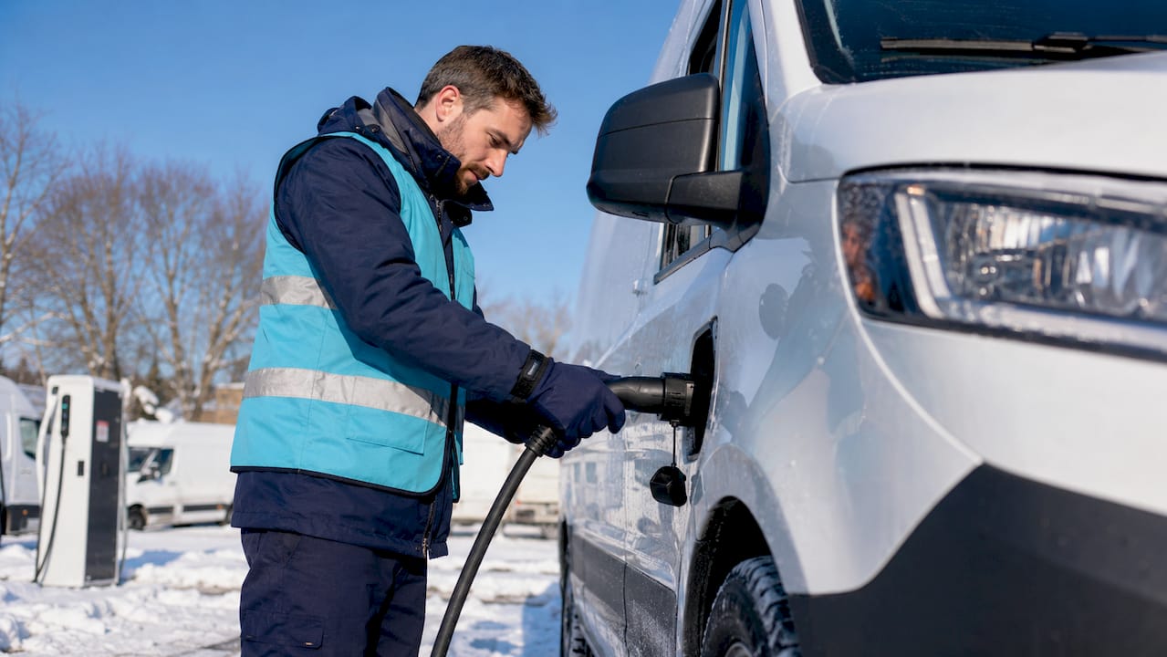 Technician charging electric van in cold winter weather