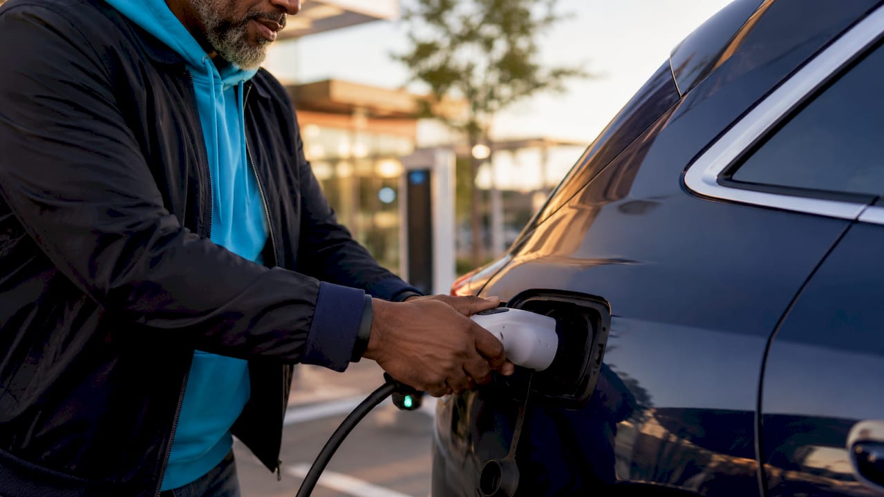 Hands plugging electric car Level 1 charger