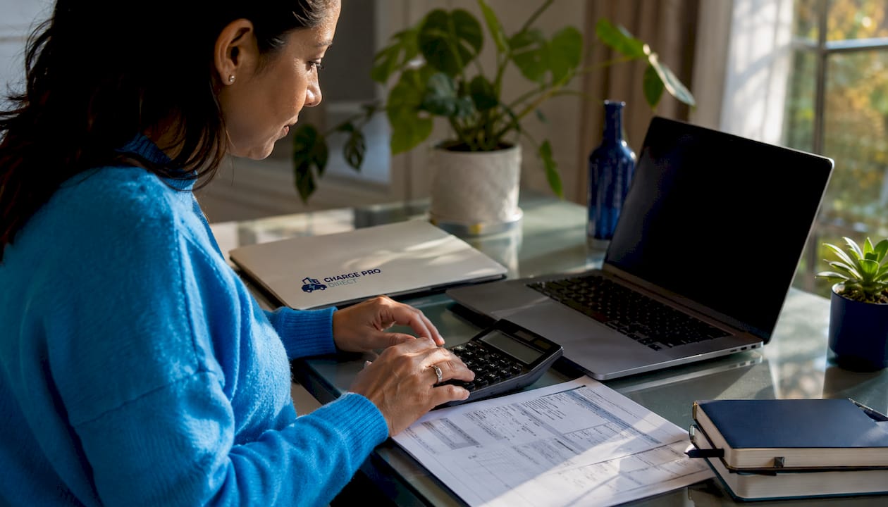 Hands with calculator and utility bill on table