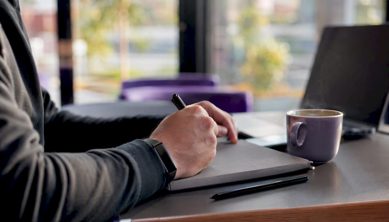 Trader hands writing pre-trade checklist