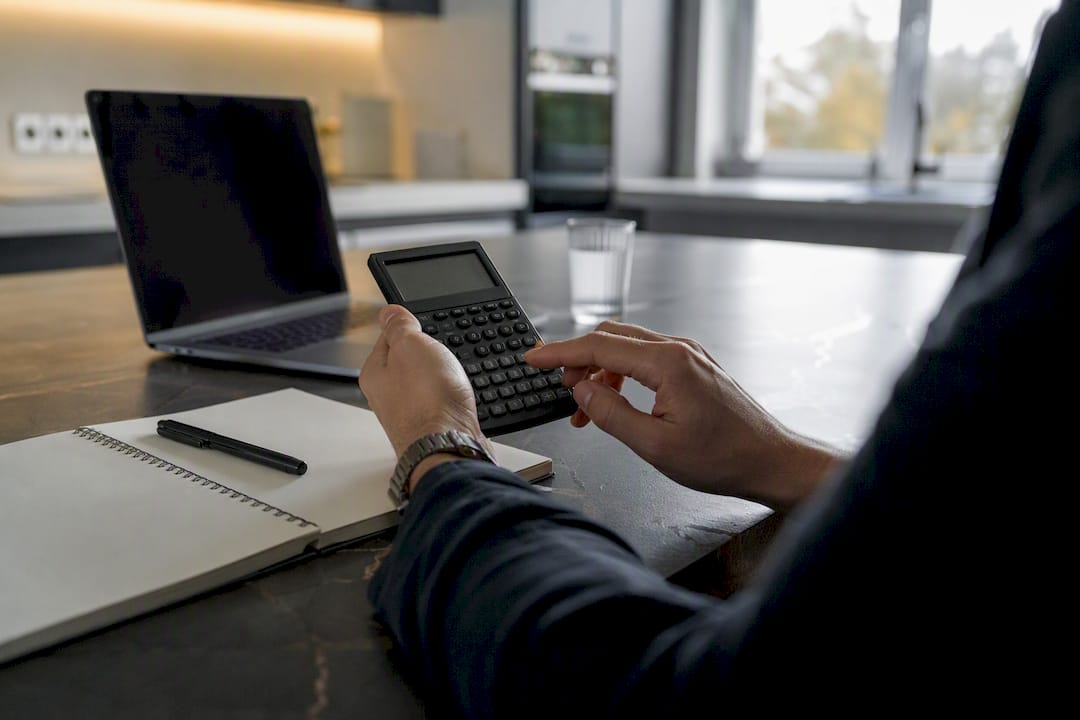 Hands calculating position size with calculator