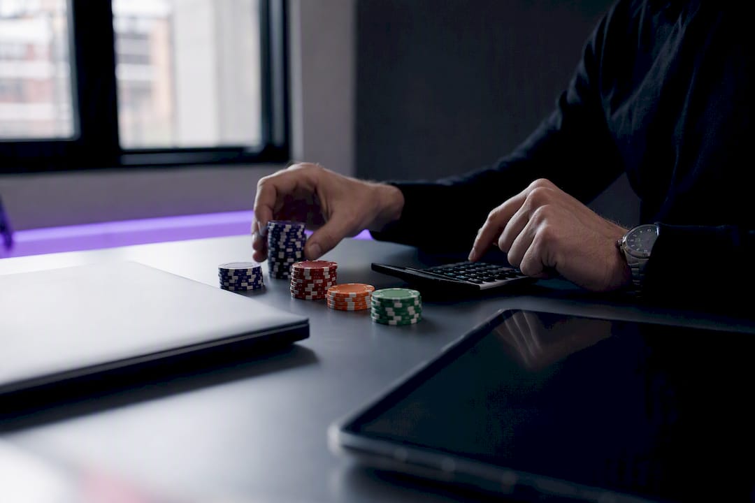 Trader's hands calculating risk with calculator