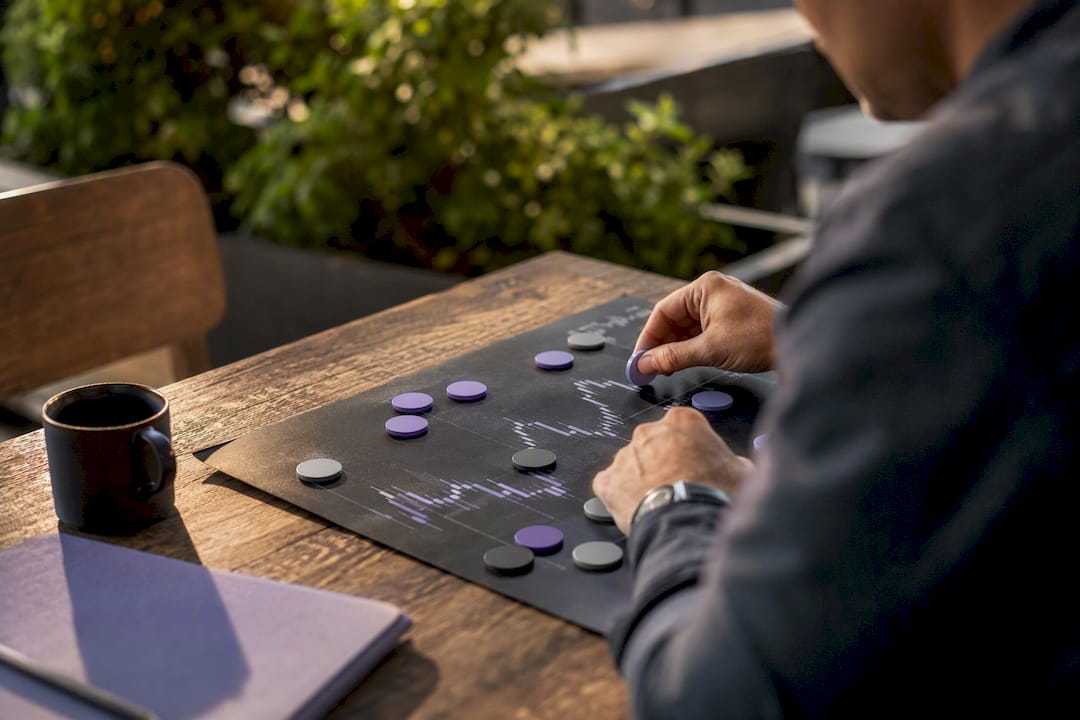 Hands placing trade tokens on analysis board