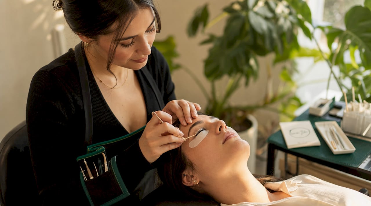 Hands performing flex check on lashes