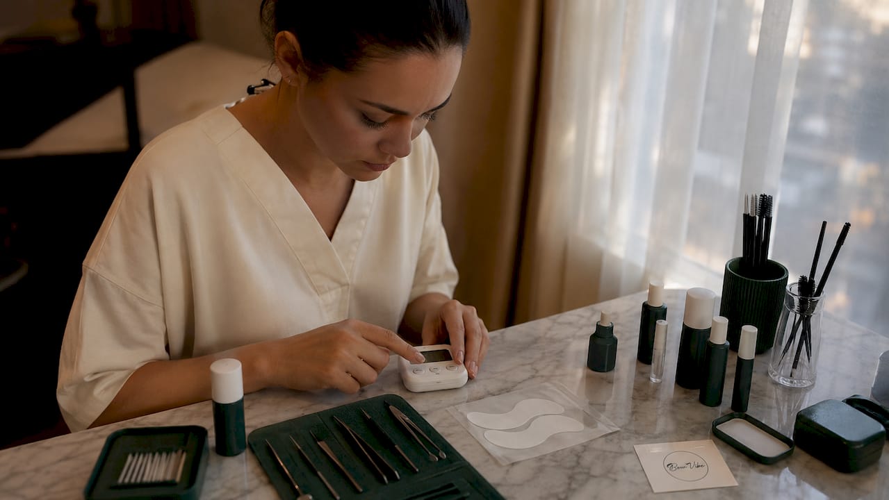Lash technician setting timer during treatment