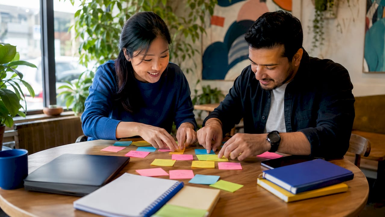 Pair of testers collaborating on acceptance criteria whiteboard