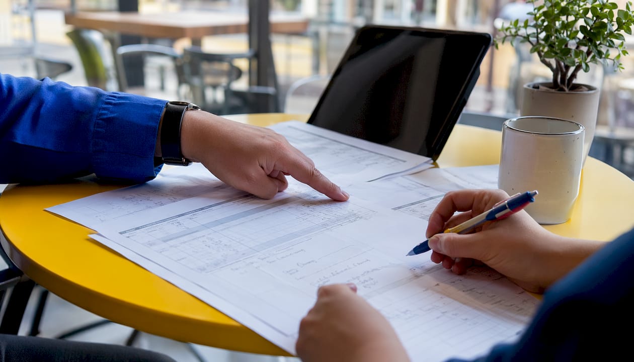 Hands pointing at use case test case tiers on paper