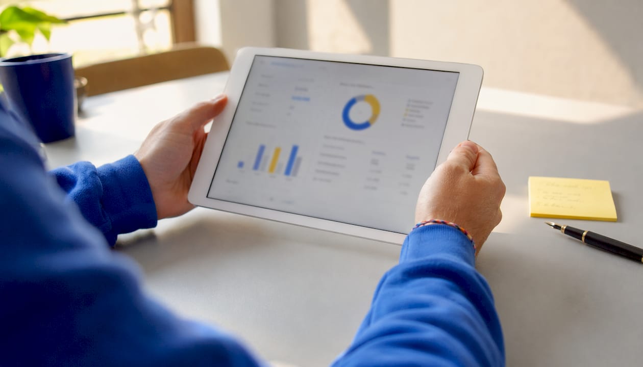 Hands holding tablet with QA metrics