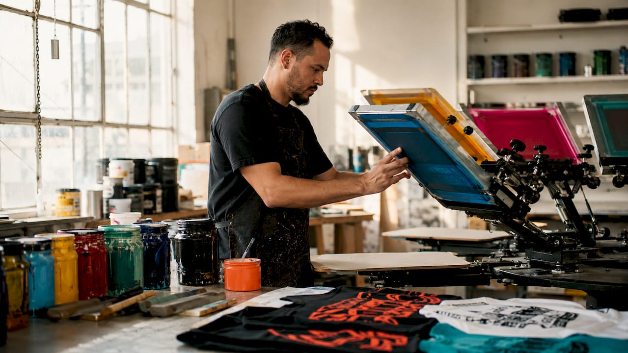 Overhead of hands setting color screens on manual press