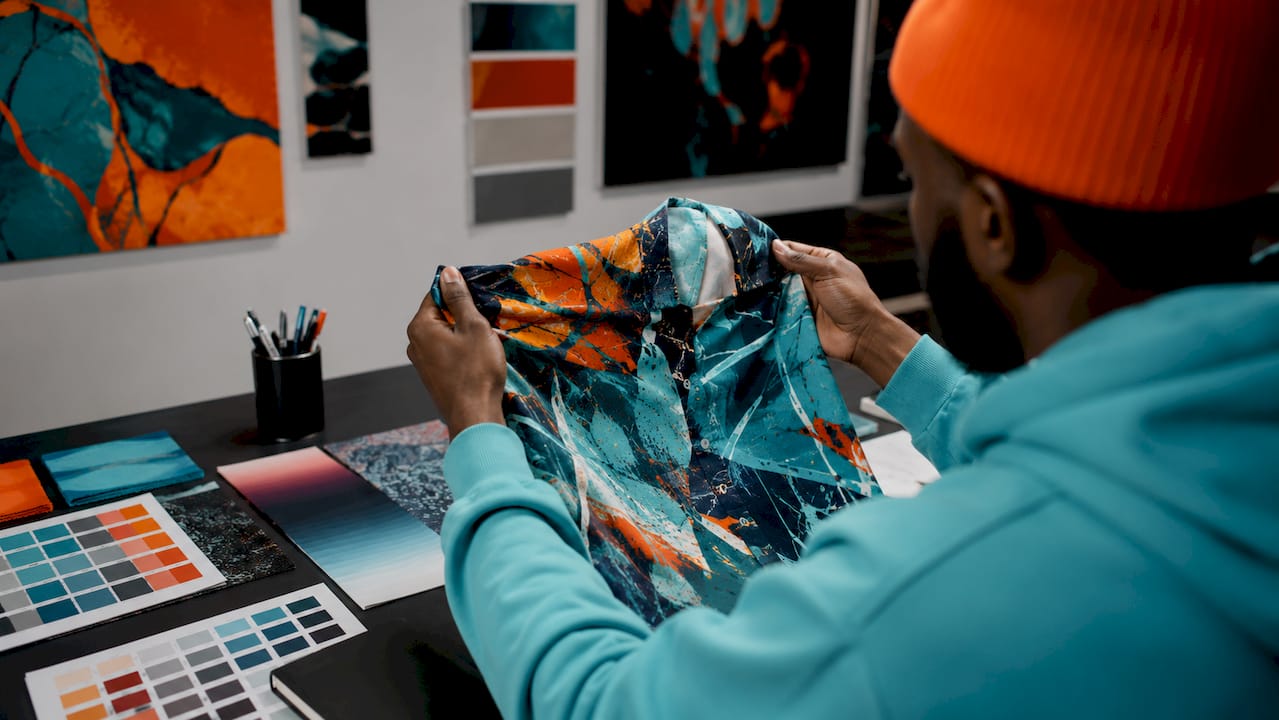 Close-up of detailed multicolor shirt print and designer hands