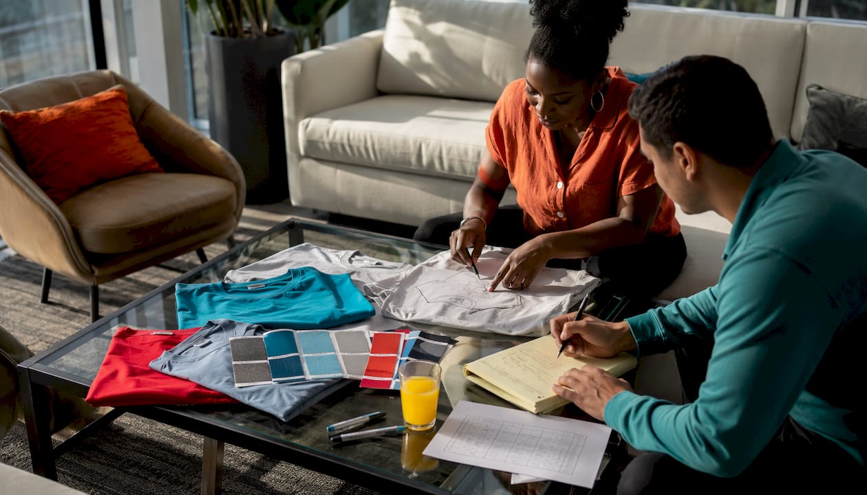 Hands discussing apparel order plans with samples on table